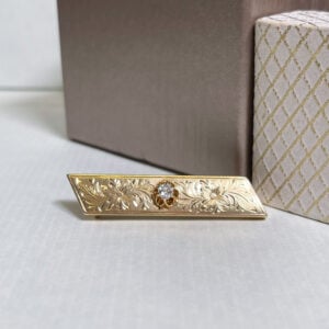 Keltakullasta valmistettu rintaneula, jossa yksi vanhahiontainen timantti n. 0,20ct.Korun on valmistanut Gabriel Gustaf Liliefelt Tampereella vuonna 1887.