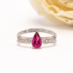 14 karaatin valkokultainen sormus, jonka keskiössä loistaa pisaran muotoon viistehiottu punainen turmaliini (rubeliitti).