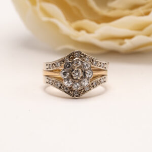 kolmesta timanttisormuksesta muodostuva näyttävä kokonaisuus on harvinainen esimerkki suomalaisesta kultasepäntyöstä, jossa eri aikakaudet ja tekijät yhdistyvät harmoniseksi kokonaisuudeksi. Yhdessä sormukset muodostavat runsaan mutta tasapainoisen ilmeen, jossa yksityiskohdat ja käsityön laatu nousevat kauniisti esiin. Uloimmat sormukset on valmistettu Heinolassa vuonna 1987 kultaseppä Johan Teofilius Lindellin toimesta. Kummassakin sormuksessa on 7 briljanttihiontaista timanttia, yhteispainoltaan 0,14 ct / sormus. Timantit on istutettu huolellisesti korostaen sormusten kaarevaa muotoa ja luoden kehys, joka sitoo kokonaisuuden yhteen. Keskimmäinen sormus on valmistettu 18k kullasta H. Lahtinen & Co:n toimesta Helsingissä vuonna 1974. Sen keskiössä on 9 briljanttihiontaista timanttia, jotka muodostavat kukkamaisen ja runsaan asetelman. Keskisormus tuo kokonaisuuteen syvyyttä ja historiallista kerroksellisuutta.