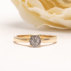 14 karaatin keltakullasta. Sen keskiössä säihkyy 11 briljanttihiontaista timanttia, jotka on istutettu tiiviiksi ja harmoniseksi kokonaisuudeksi.