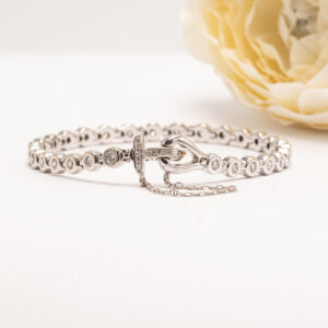 18 karaatin valkokullasta valmistettu timanttirannekoru on rakennettu selkeälinjaiseksi ja tasapainoiseksi kokonaisuudeksi.