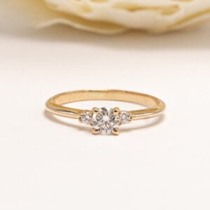 Sormuksen keskiössä säihkyy briljanttihiottu preloved-timantti, painoltaan 0,27. Keskikiveä kehystävät sirosti istutetut sivutimantit.