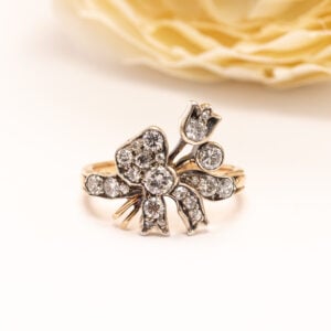 Hurmaava 14 karaatin keltakultainen sormus, jossa romanttinen kukka-aihe herää eloon säihkyvien timanttien kautta.