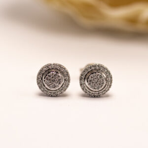 valkokultaiset timanttikorvakorut briljanttihionnalla. Pyöreä muoto ja säihkyvä kivikehä luovat klassisen ja huolitellun ilmeen.