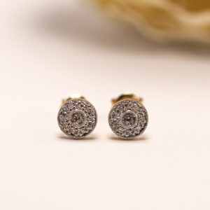 kultaiset timanttikorvakorut briljanttihionnalla. Pyöreä muoto ja säteilevä kiviasettelu luovat näyttävän ja ajattoman kokonaisuuden