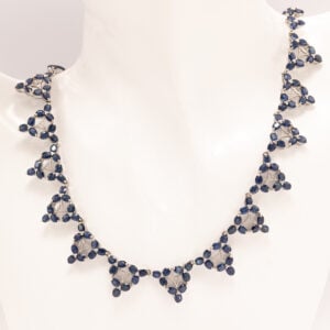 Näyttävä 14 karaatin valkokultainen safiirikaulakoru, joka hurmaa runsaudellaan ja syvänsinisellä sävymaailmallaan.