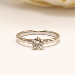 Valkokultainen timanttisormus klassisella solitaarimallilla. Pelkistetty ja ajaton muotoilu korostaa kauniisti sormuksen keskellä säihkyvää timanttia.