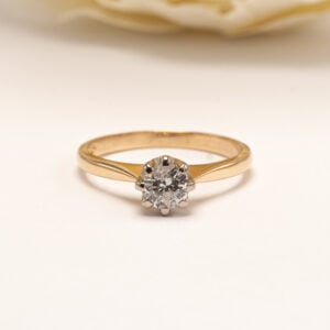 Keltakultainen timanttisormus vuodelta 2000. Ajattoman selkeä muotoilu korostaa sormuksen keskellä säihkyvää timanttia ja tekee korusta klassisen.