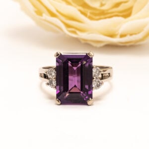 14k valkokultainen sormus, jonka keskipisteenä on suorakaiteen muotoon viistehiottu, poikkeuksellisen laadukas ametisti sekä 4 kpl timantteja.