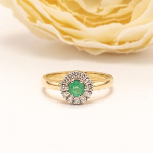 Sormuksen keskellä säihkyy pyöreä viistehiottu smaragdi (0,30 ct), jonka raikas vihreä sävy tuo koruun elävyyttä ja luonnollista viehätystä.