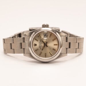 Rolex Lady-Date on klassinen ja sirolinjainen rannekello, joka edustaa Rolexin ajatonta muotoilua pienemmässä koossa. Tämä vuonna 1985 valmistettu malli yhdistää hillityn ulkonäön ja laadukkaan viimeistelyn tavalla, joka kestää aikaa. Kellossa on teräksinen kuori ja ranneke, jotka tekevät kokonaisuudesta kestävän ja monikäyttöisen. Vaalea, patinoitunut taulu antaa kellolle persoonallista ilmettä ja kertoo sen historiasta. Selkeät indeksit ja päivämääränäyttö Cyclops-suurennuslasilla tuovat käytännöllisyyttä ja parantavat luettavuutta. Oyster-kuori suojaa koneistoa luotettavasti, ja automaattikoneisto varmistaa tasaisen käynnin ilman pariston tarvetta. Kompakti koko tekee kellosta miellyttävän käyttää ja helposti yhdisteltävän erilaisiin tyyleihin. Kello on käynyt läpi täyshuollon maaliskuussa 2026, joten sen tekninen kunto on varmistettu ja se on valmiina käyttöön pitkäksi aikaa eteenpäin.