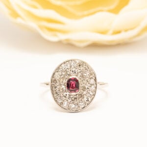 Platinasormus rubiinilla ja timanteilla. Ovaali rubiini 0,25 ct ja 28 timanttia. Ajaton vintage-jalokivisormus.