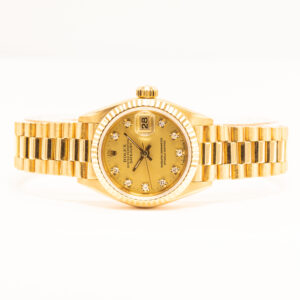 Rolex Lady-Datejust 26 mm 18k keltakultaa, timantti-indekseillä ja automaattikoneistolla. Täyshuollettu 6/2026, huoltosaate mukana.