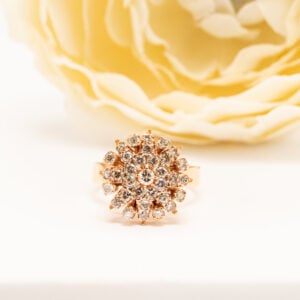 Näyttävä 18k keltakultainen vintage-sormus, jossa 33 pyöreää timanttia yhteensä 0,71 ct. Runsas kukkamainen istutus ja lämmin ilme.