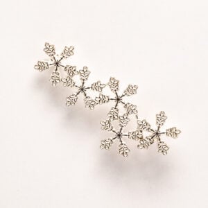Kalevala Korun hopeinen Lumihiutale-rintaneula, suunnittelija Terhi Koivisto. Vuonna 2009 julkaistu korumalli on saanut inspiraationsa talven jääkiteistä.