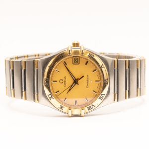 Omega Constellation Quartz 33 mm. Klassinen kulta-teräskello, jossa kullanvärinen kellotaulu, roomalaisin numeroin koristeltu kehä ja päivämääränäyttö.